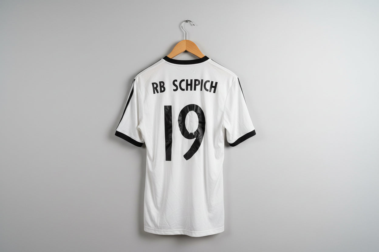 White sports jersey with black text and numbers on a hanger against a white wall.