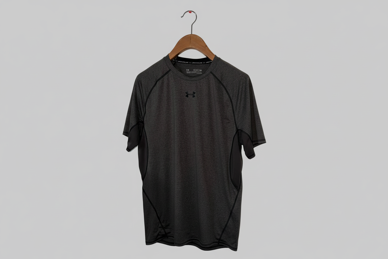Black t-shirt on a hanger against a gray background