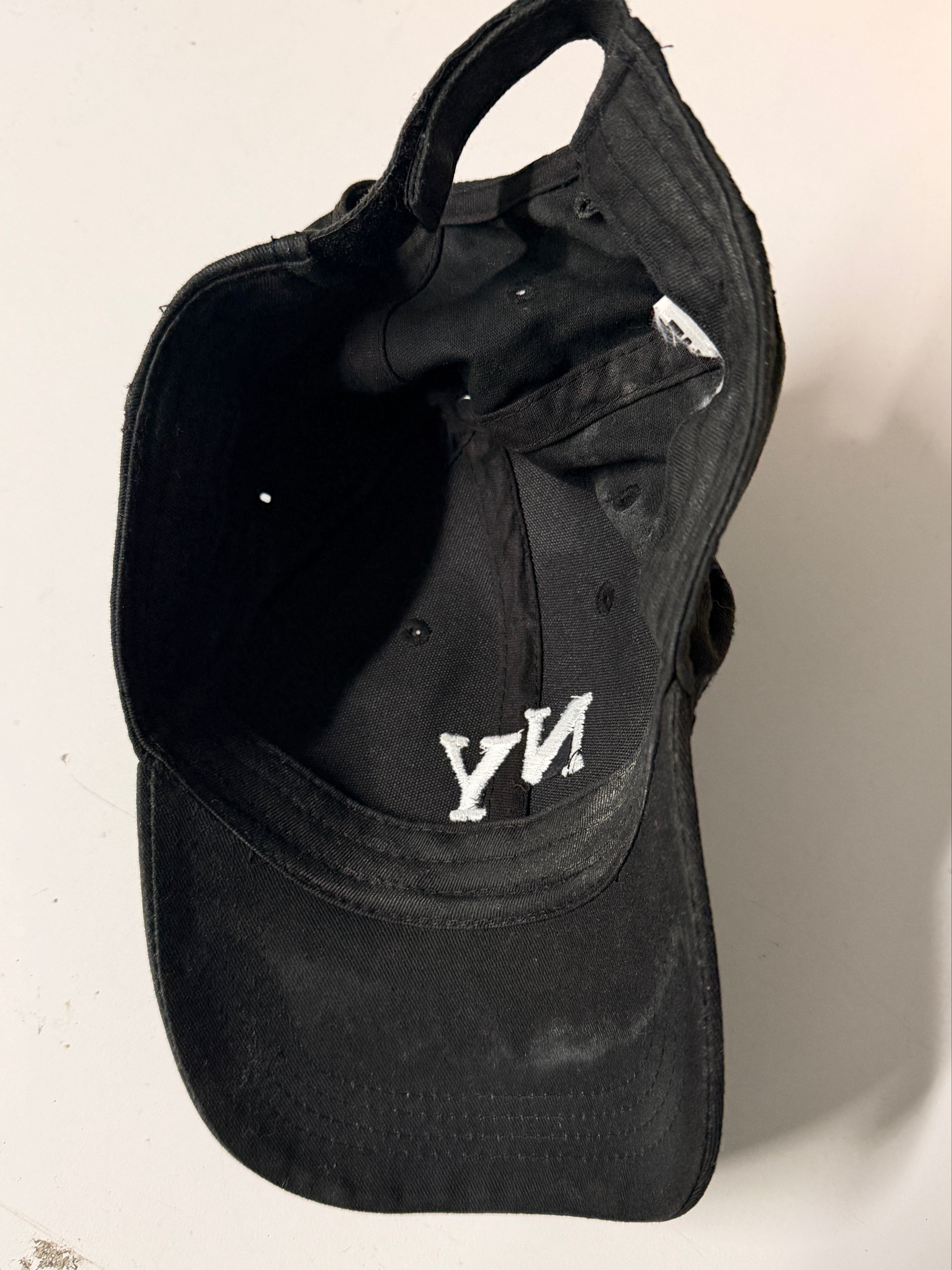 Black cap with a logo on a light gray background