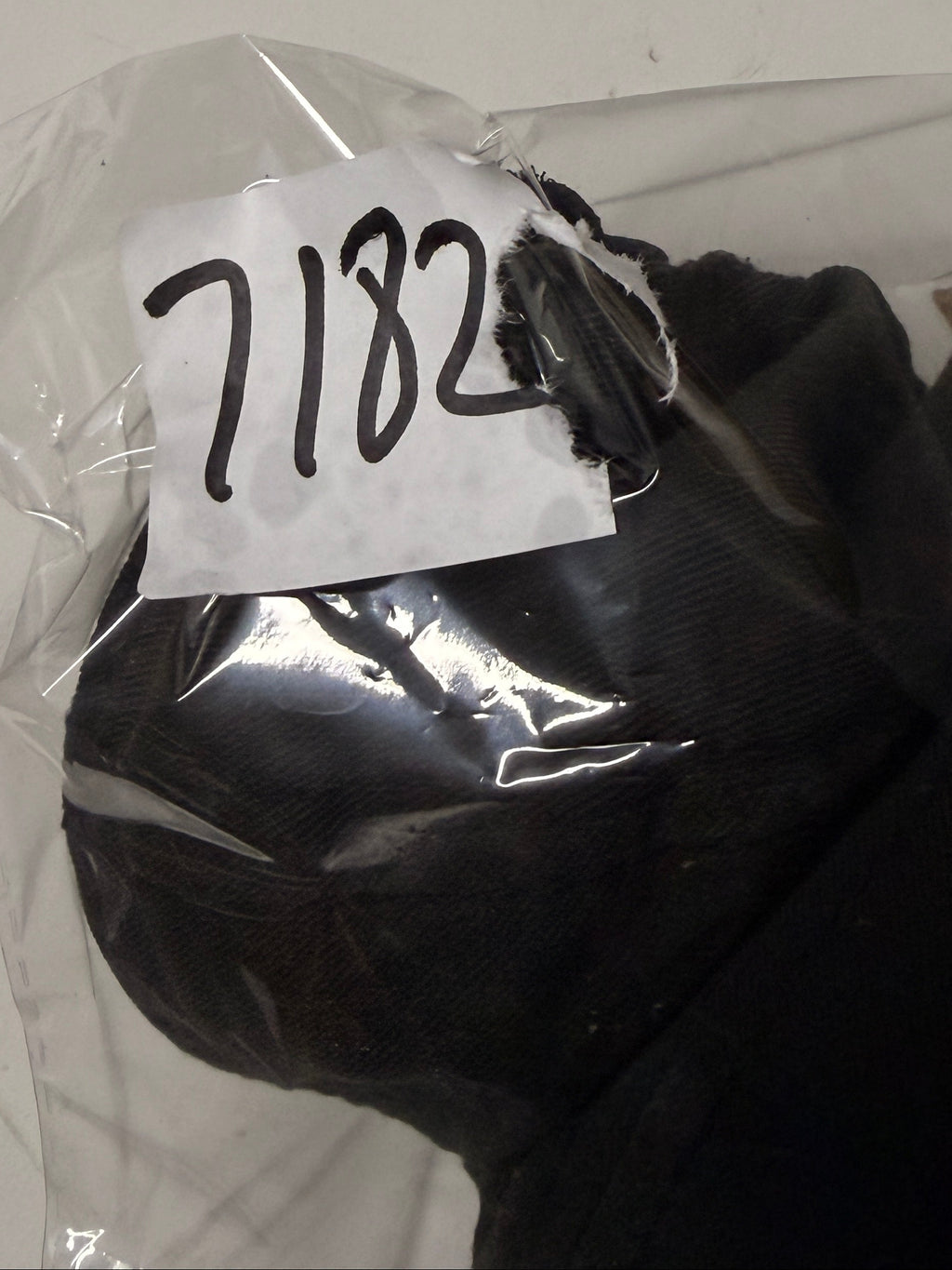 Black glove with a white label on a white background