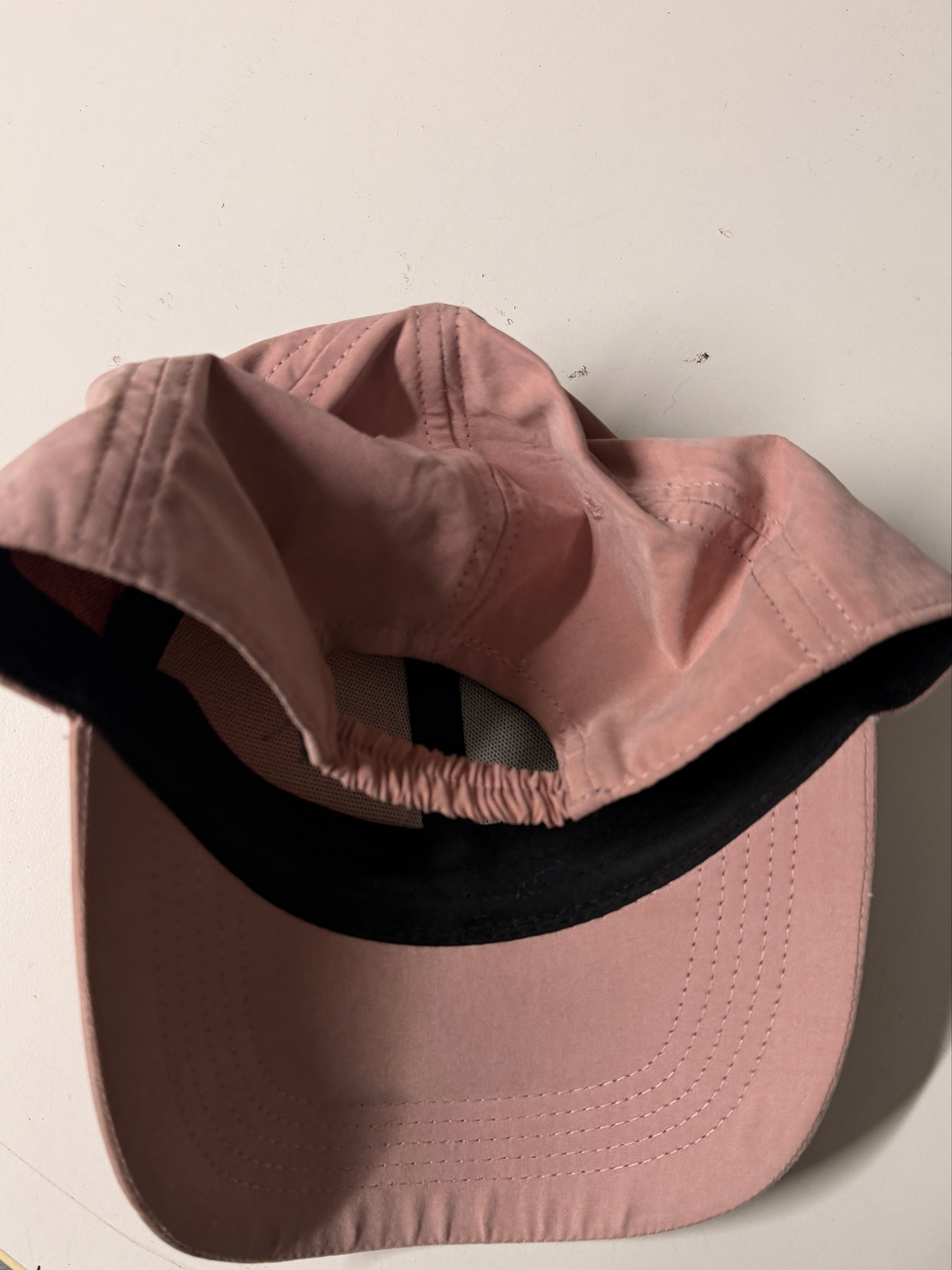 Pink bucket hat with black interior on a light background