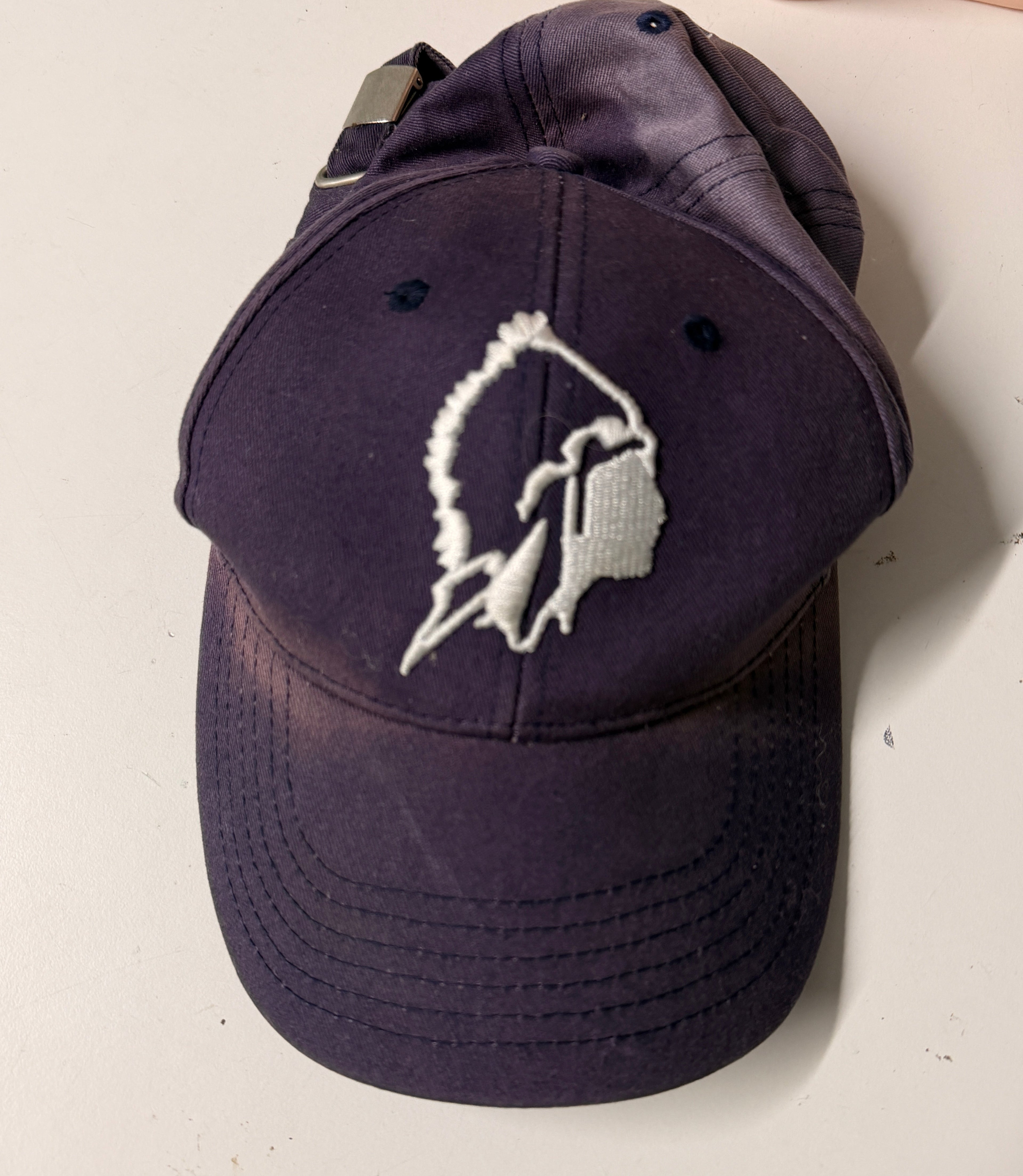 Black cap with white logo on a light gray background