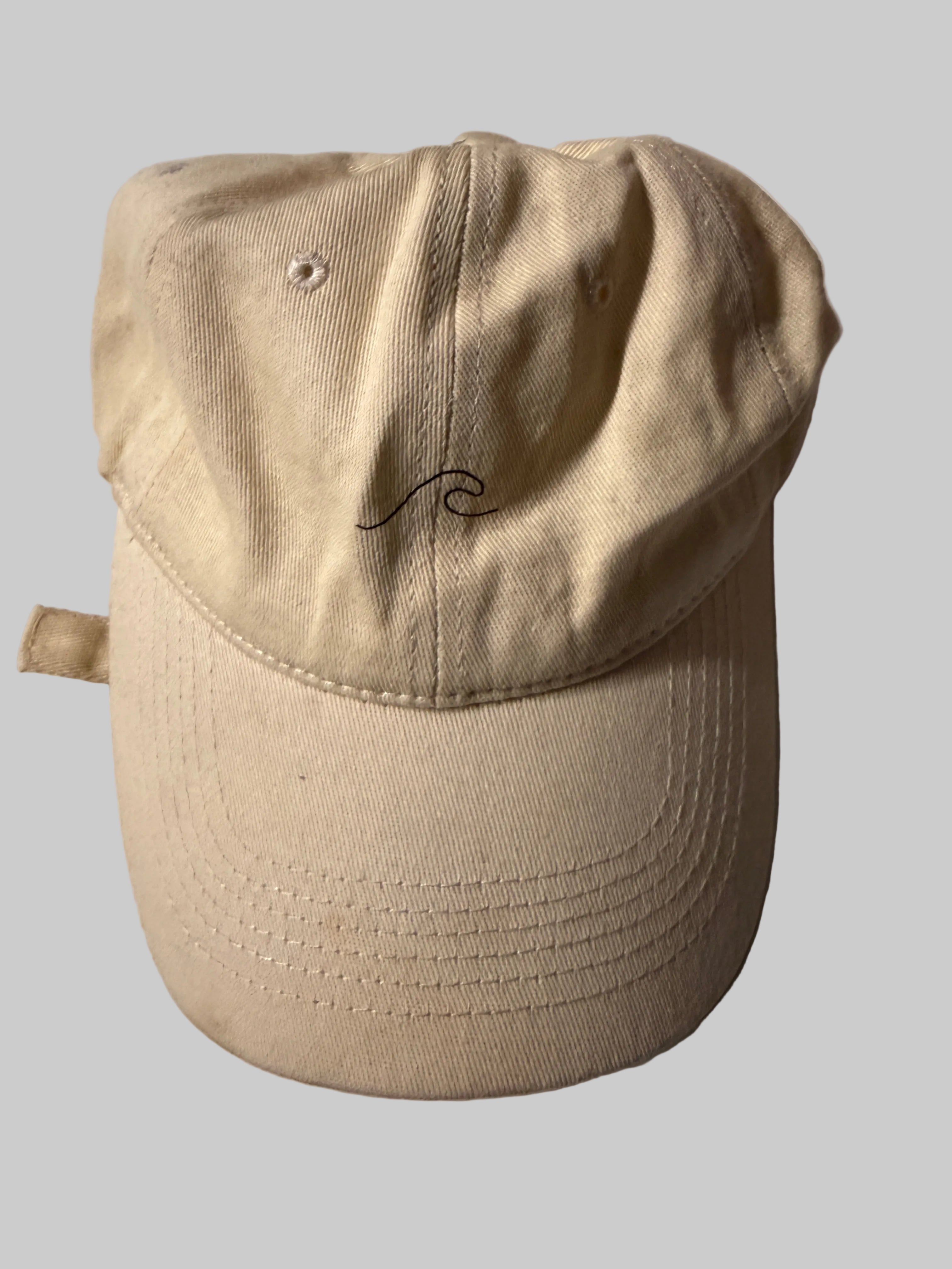 Beige cap with a small logo on a white background