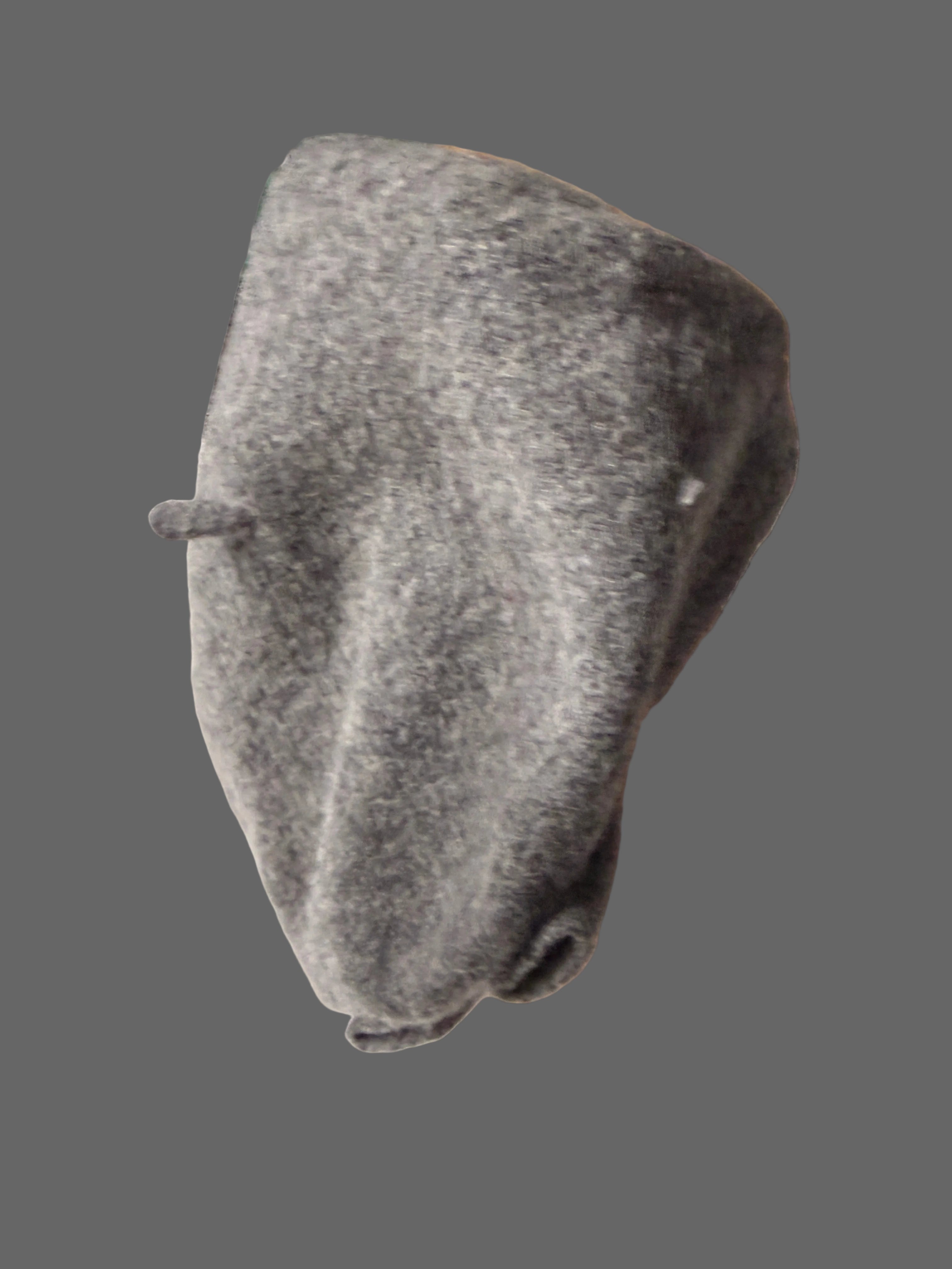 Gray sock on a white surface with a cardboard box and green plastic crate in the background