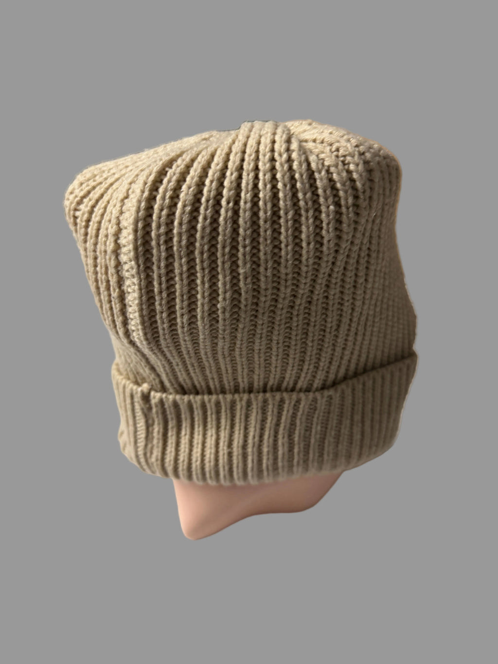 Knitted brown beanie on a mannequin head with a blurred background