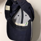 Navy blue cap with a brand label on a light background