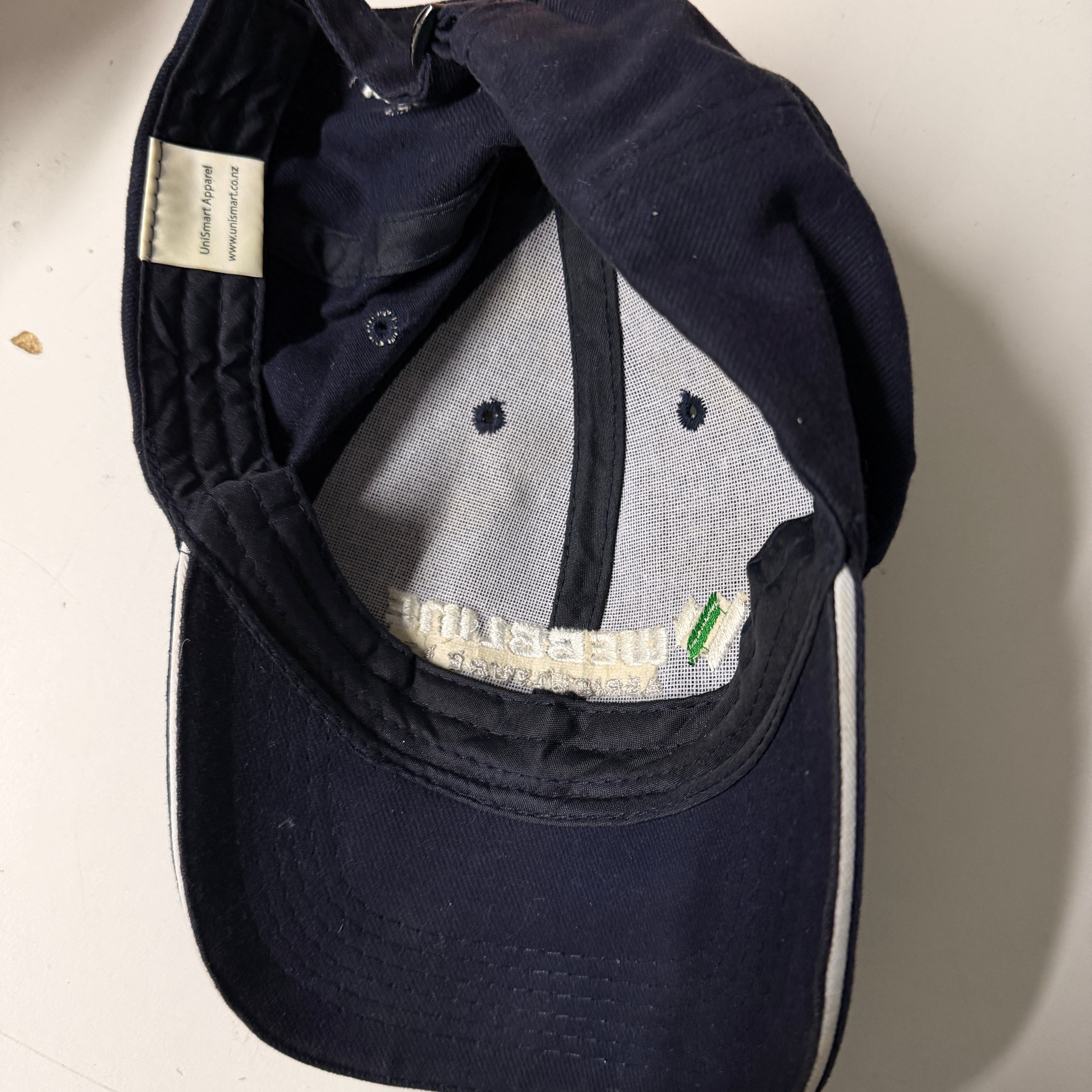 Navy blue cap with a brand label on a light background