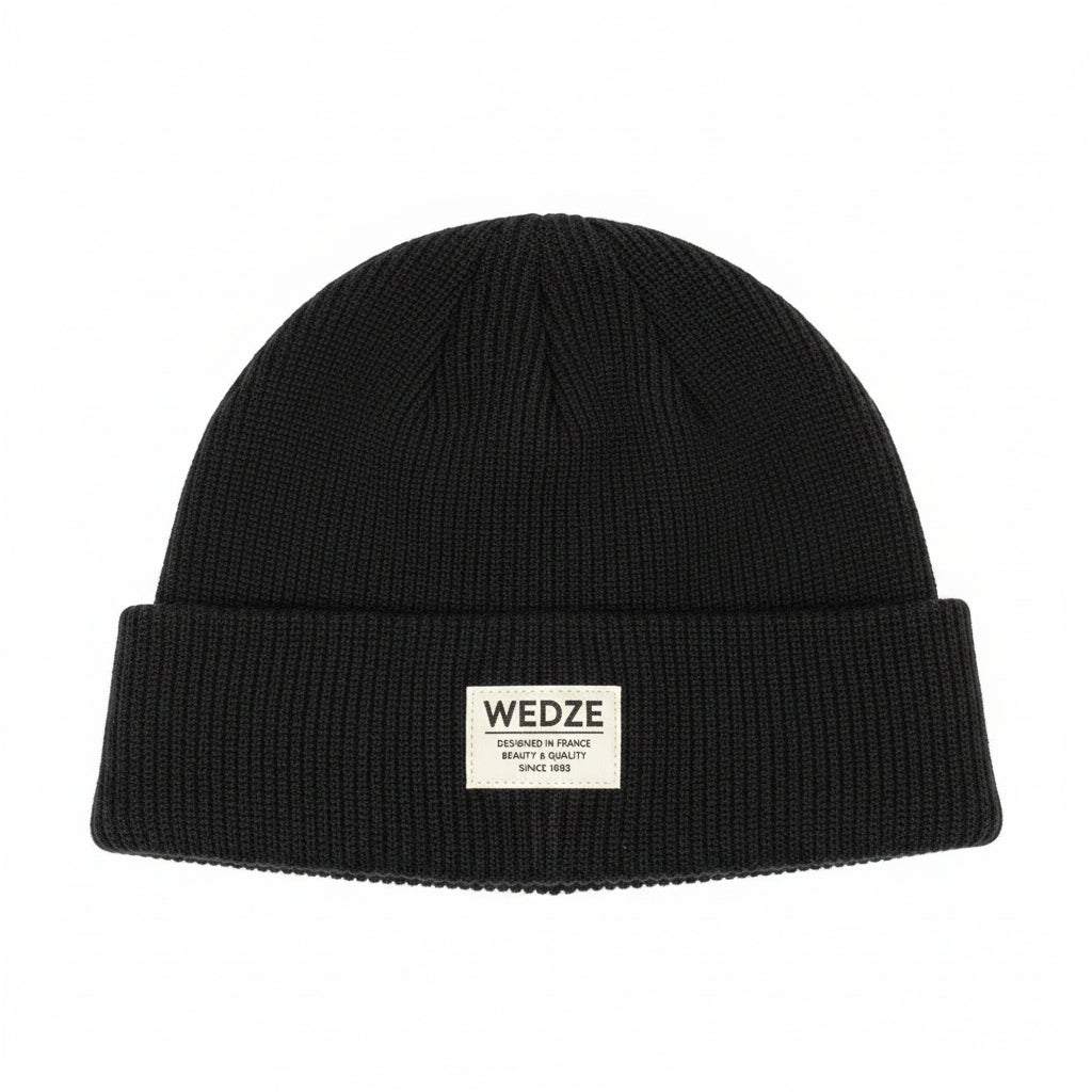 Dark knit beanie with a brand tag on a white surface