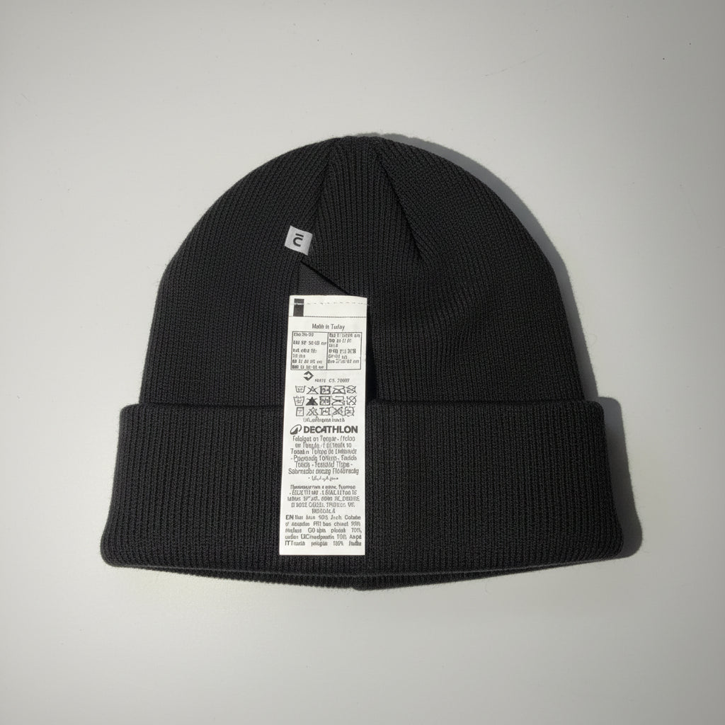 black knit beanie with a tag on a white surface