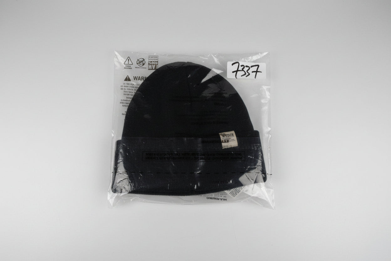 Black power tool in clear plastic packaging on a white surface