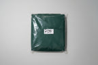 Pair of scissors in clear plastic packaging with a label on a green background