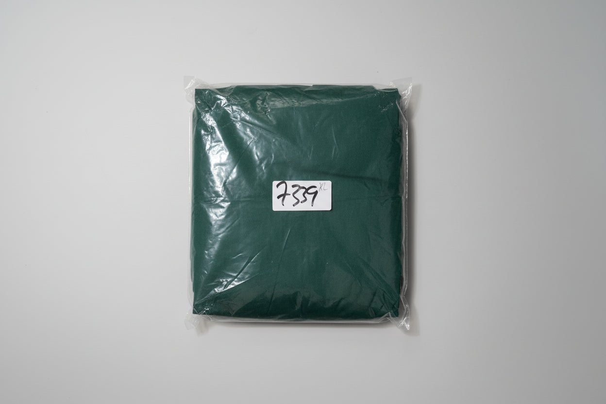 Pair of scissors in clear plastic packaging with a label on a green background