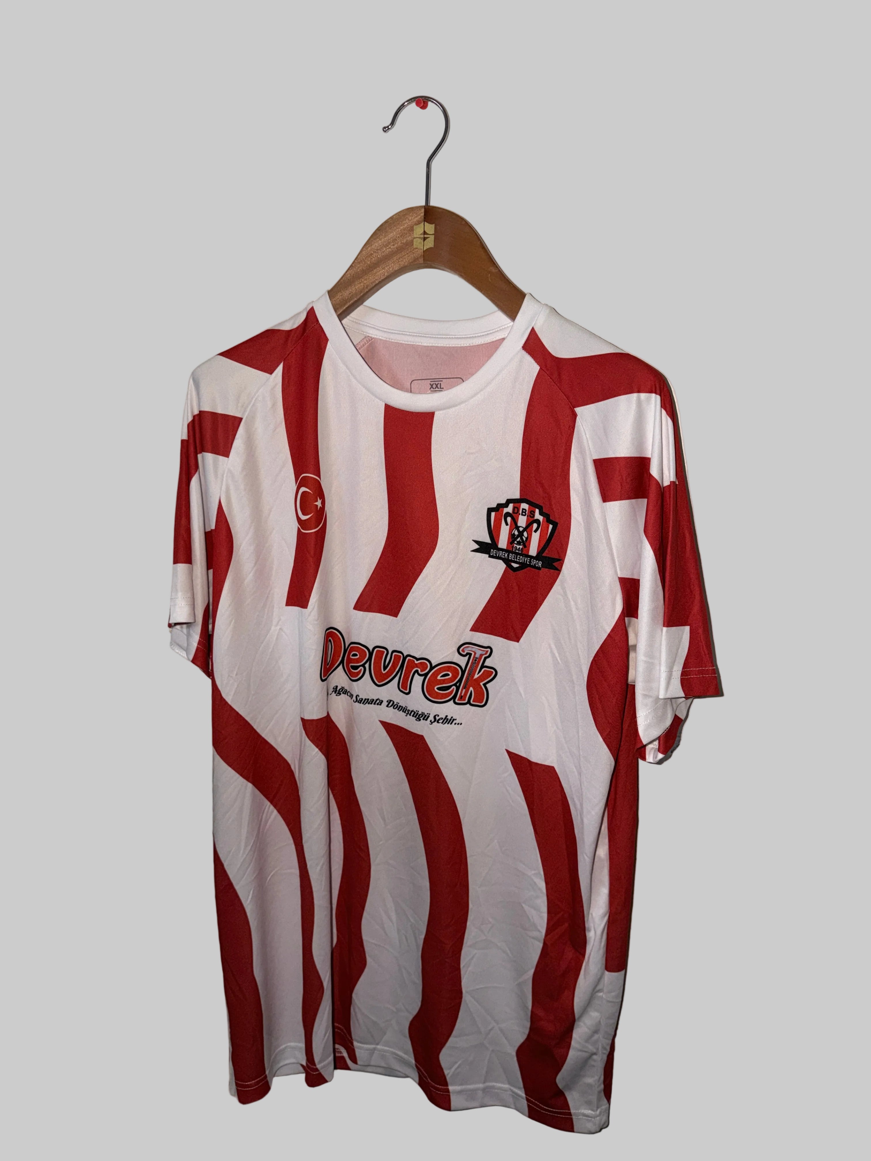 Red and white striped sports jersey with 'Devorek' branding on a hanger against a white wall.