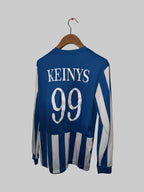 Blue and white sports jersey with 'Keanys 99' printed on a wooden hanger against a white wall.