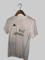 White t-shirt with green text and Adidas logo on a hanger against a white background
