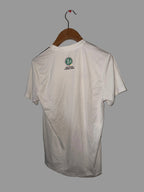 White shirt with a logo on a hanger against a white wall