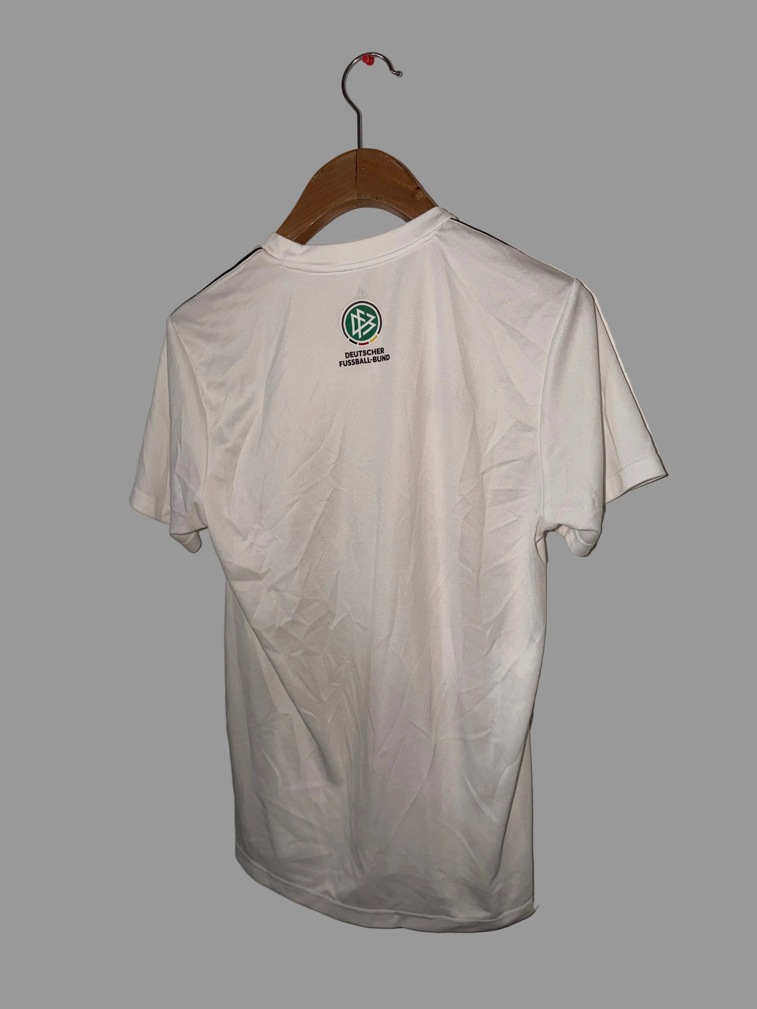 White shirt with a logo on a hanger against a white wall