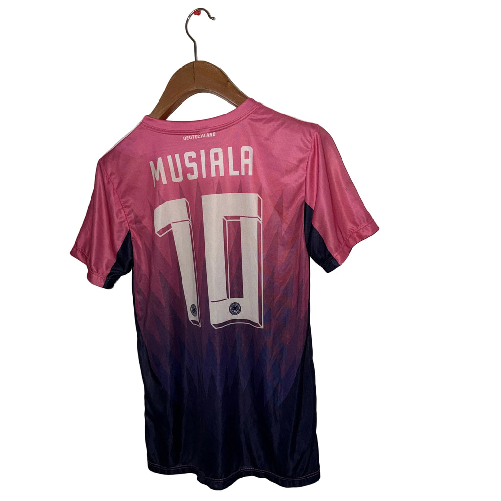 Pink and black sports jersey with 'Musiala' and number '10' on a hanger against a white wall.