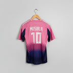 Pink and blue sports jersey with 'Musiala 10' printed on it, hanging on a wooden hanger against a white wall.