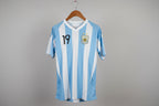 Blue and white striped sports jersey with number 19 on a hanger against a white wall.