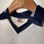 Navy blue sports jacket with visible brand label on a textured surface