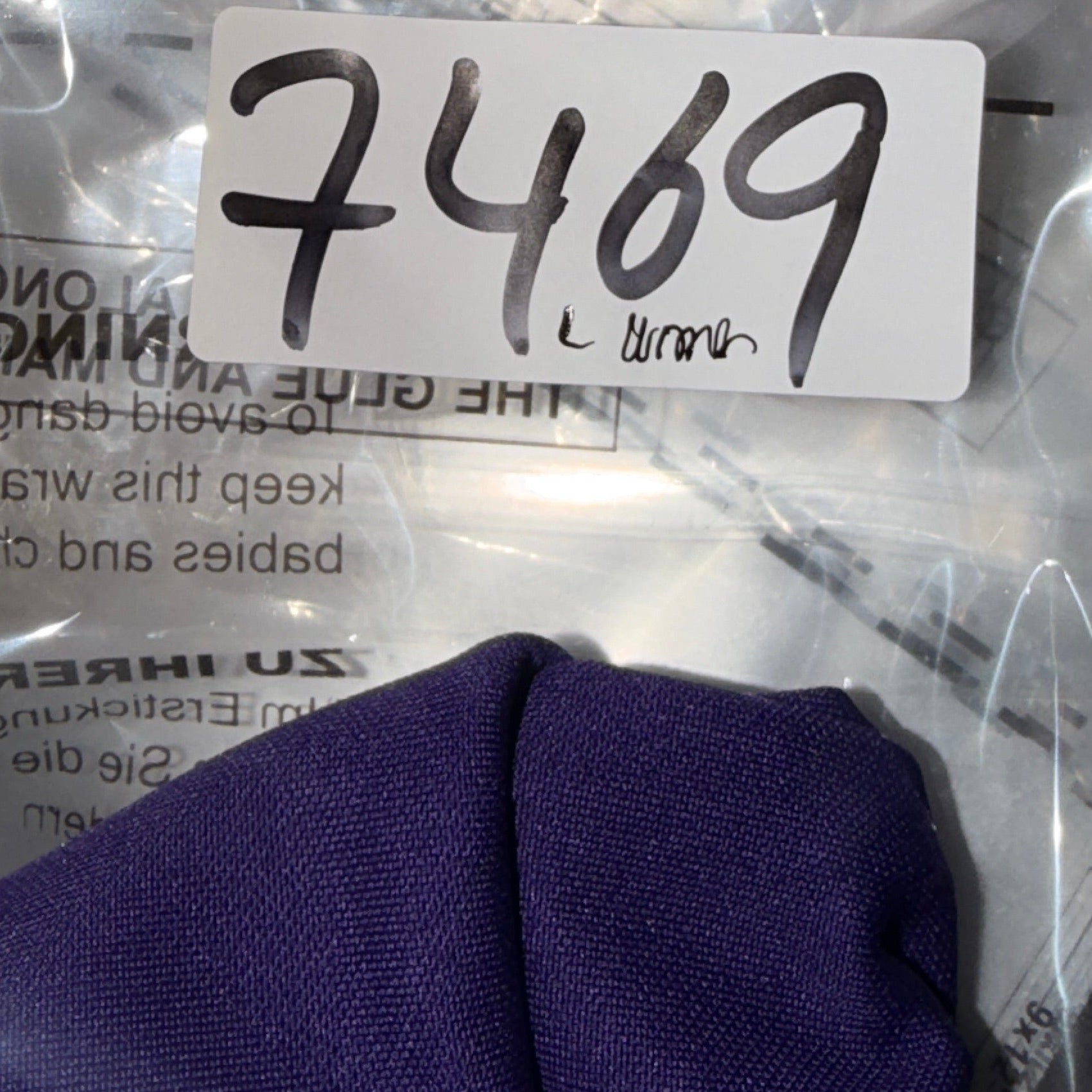 Metallic object with a label '7469' inside clear plastic packaging.