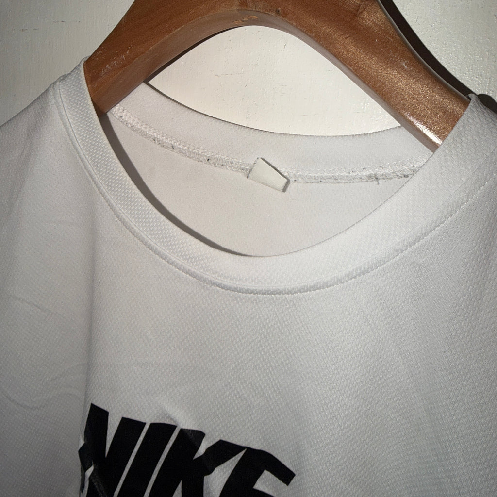 White Nike shirt on a hanger with a close-up of the collar and brand logo.