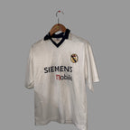 White sports jersey with Siemens and mobile logos on a wooden hanger against a white wall.