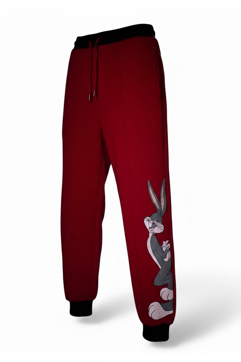 A pair of red jogging pants with an iconic cartoon character printed on the side, displayed on a hanger.