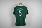 Green sports jersey with number 5 on a white floor