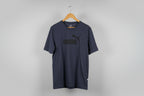Navy blue sweatpants on a wooden hanger against a white background