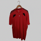 Red sports jersey with black accents on a hanger against a gray background