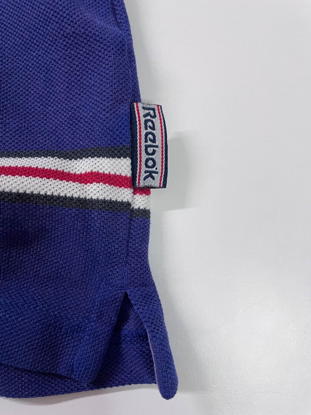 Vintage Men's Reebok Athletics Dept. Blue stripe polo shirt in M|L28 W20|SKU 4140