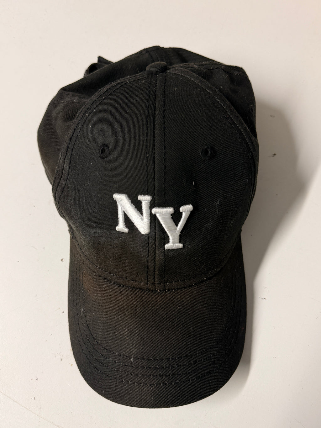 Black cap with 'NY' logo on a white background