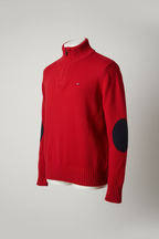 A red knit sweater with black circular elbow patches, laid flat against a white background.
