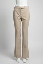 A pair of beige flared trousers displayed on a white mannequin against a light gray studio background.