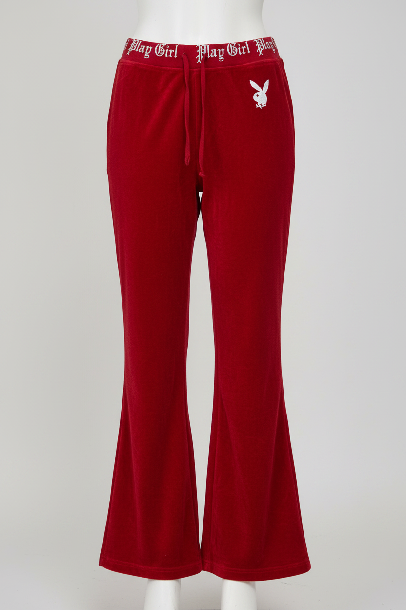 A pair of vintage red women's joggers pants with a logo on the left leg.